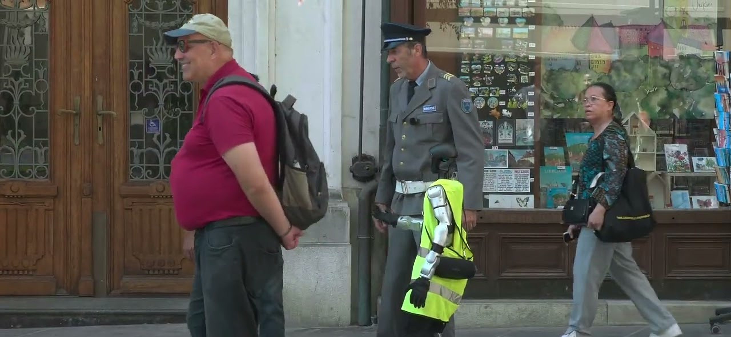 Franci Kek as a policeman and Jože in a high-visibility vest stopping passers-by on Čopova Street in Ljubljana